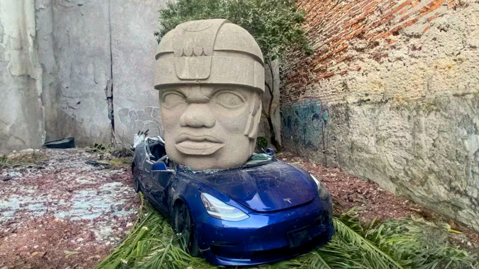 Cabeza olmeca aplasta a un Tesla en Ciudad de México