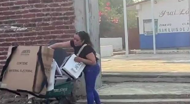 8. Funcionaria de casilla transporta material en una carretilla material